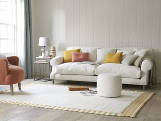 Relaxed lounge with comfy cushioned sofa in white, and color pop scatter pillows.