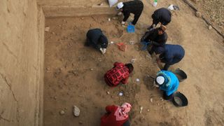 Archaeologists are shown here excavating the well-preserved surface at an archaeological site called Xiamabei in northern China, revealing stone tools, fossils, ochre and red pigments.
