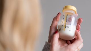 woman holding a container of breast milk