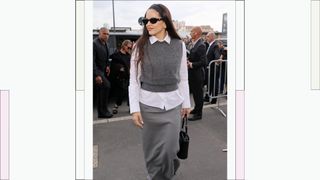 Rosalía wears a grey sweater vest, a white shirt and black sunglasses as she attends the Prada fashion show during the Milan Fashion Week Womenswear Spring/Summer 2024 on September 21, 2023 in Milan, Italy.