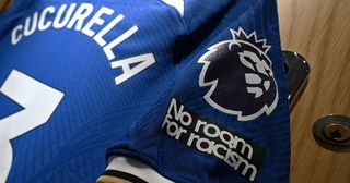 A detailed view of the No room for racism logo is seen on the shirt of Marc Cucurella inside the Chelsea dressing room prior to the Premier League match between Chelsea FC and Liverpool FC at Stamford Bridge on August 13, 2023 in London, England.