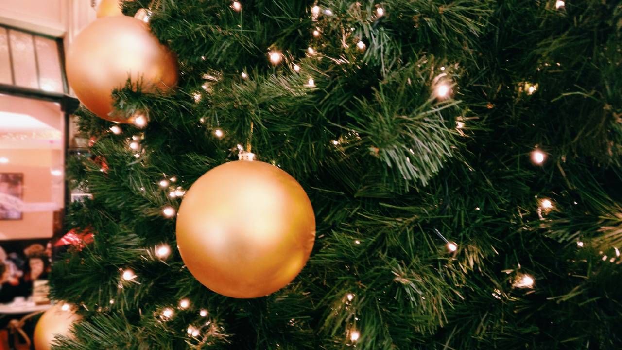 Close up of gold lights and baubles on a Christmas tree