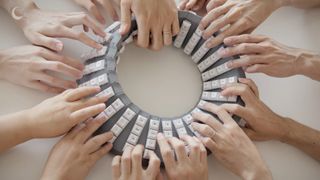 Google Japan's mobius strip double sided keyboard, being used on all sides by multiple hands