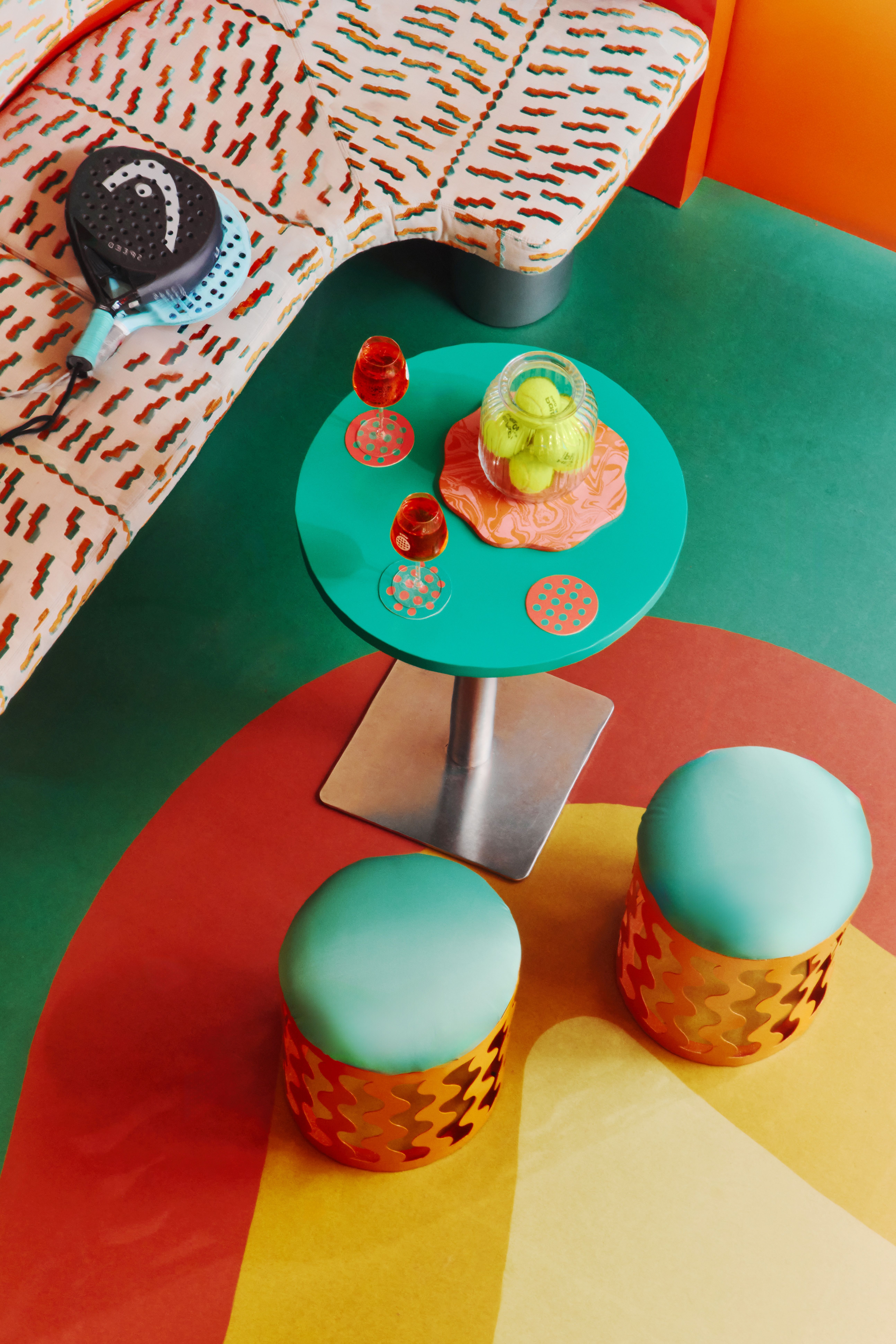 The restaurant and bar of a sports club features gradient green, orange, ochre, and yellow floors, walls, bar tiles, and furniture, each characterized by a whimsical essence.