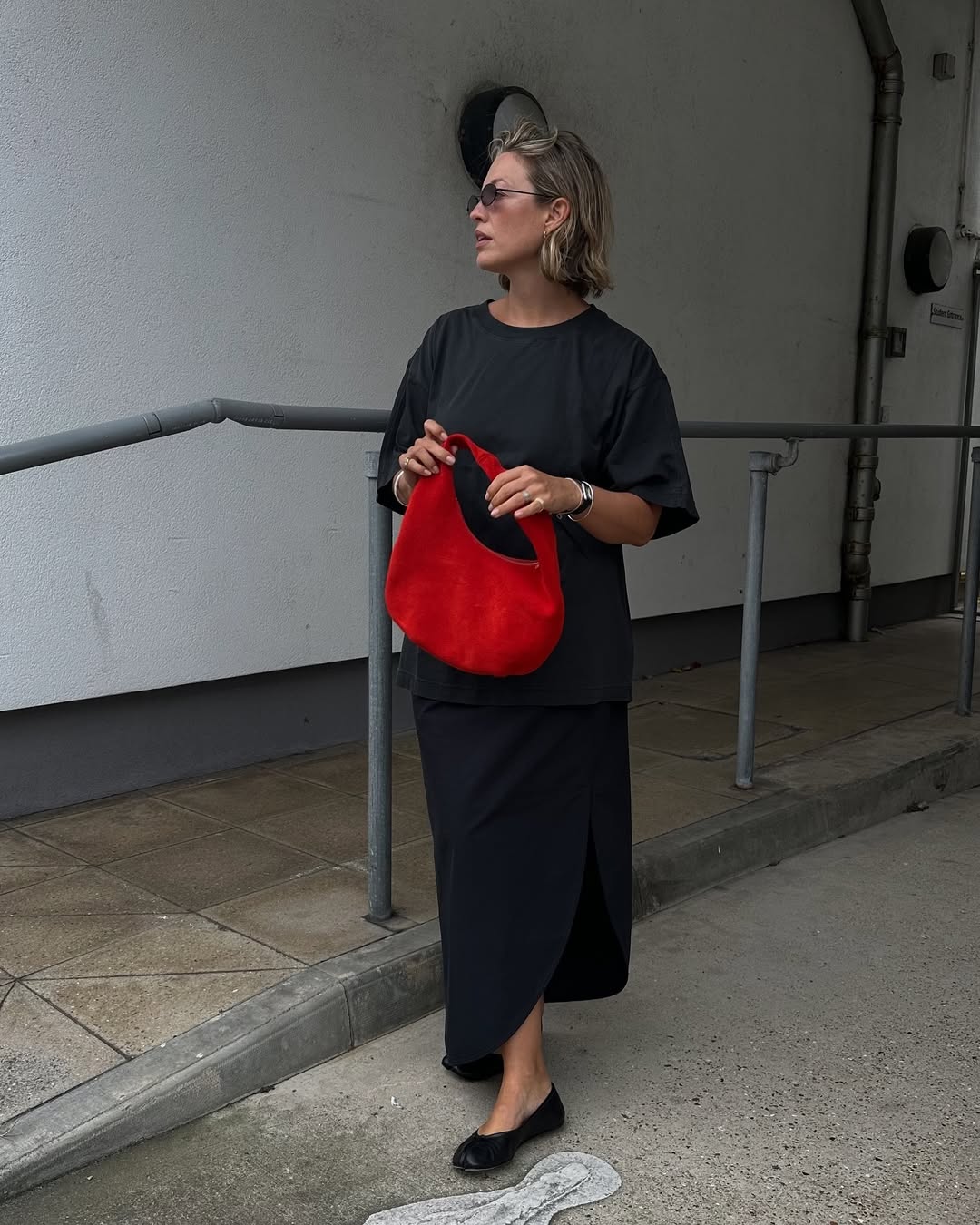 @alexisforeman wears a black t-shirt, black skirt, ballet flats and red bag