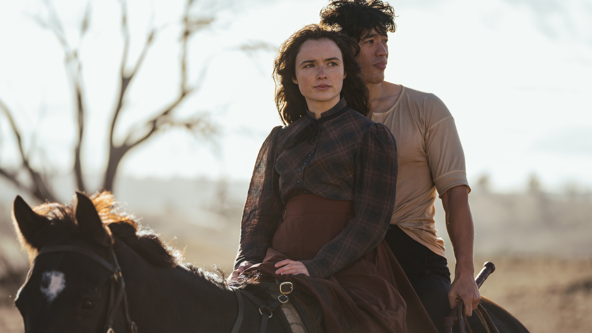 Phillipa Northeast as Sybylla and Christopher Chung as Harry sit astride a horse on Netflix's 'My Brilliant Career.'