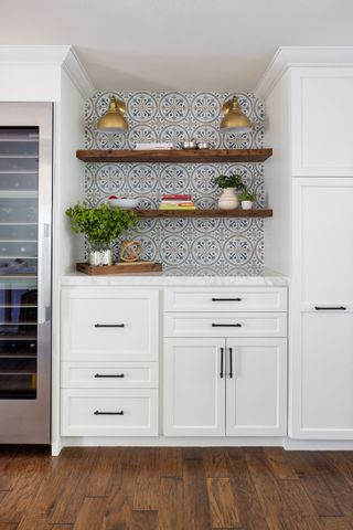 kitchen with white cabinets dark wood floor open shelves with tiled backsplash and wine fridge