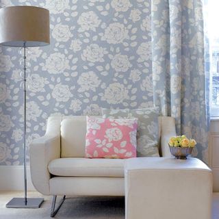 living room with sofa and bold florals wallpaper