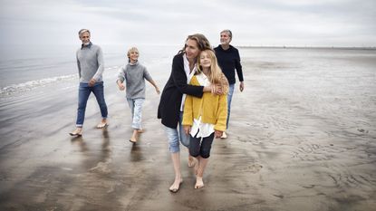 Three generations of a family walk on the beach. 