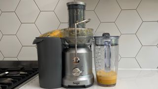 Breville the Juice Fountain Cold on a kitchen countertop filled with orange juice
