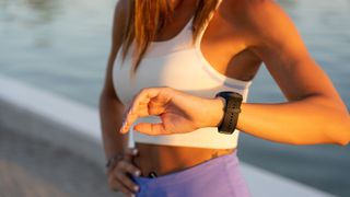 a photo of a woman looking at her running watch