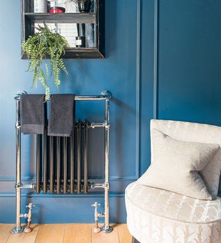 blue panelled bathroom with freestanding bath and radiator