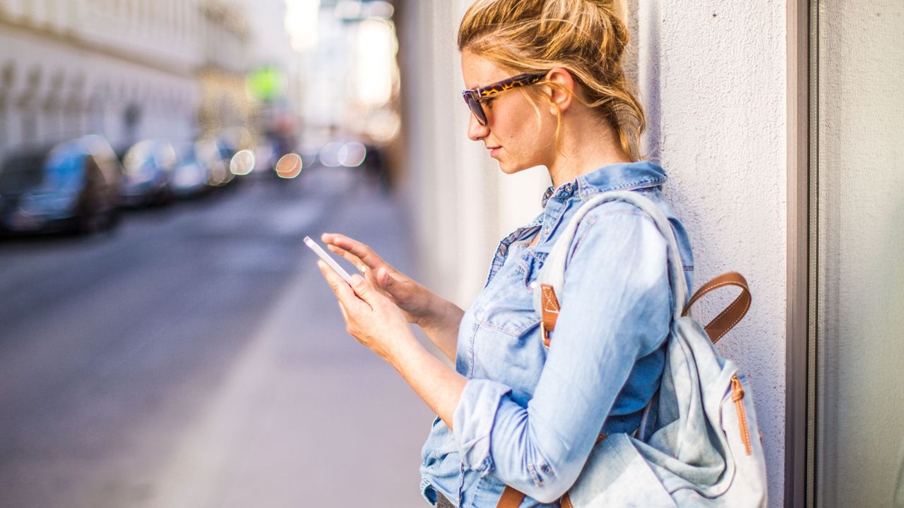 Woman with backpack checking her phone