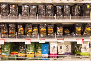 An image of a grocery store shelf displaying numerous packets of coffee