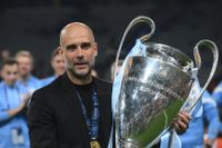 Pep Guardiola poses with the Champions League trophy after Manchester City's win in the final over Inter in June 2023.