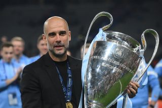 Pep Guardiola poses with the Champions League trophy after Manchester City's win in the final over Inter in June 2023.