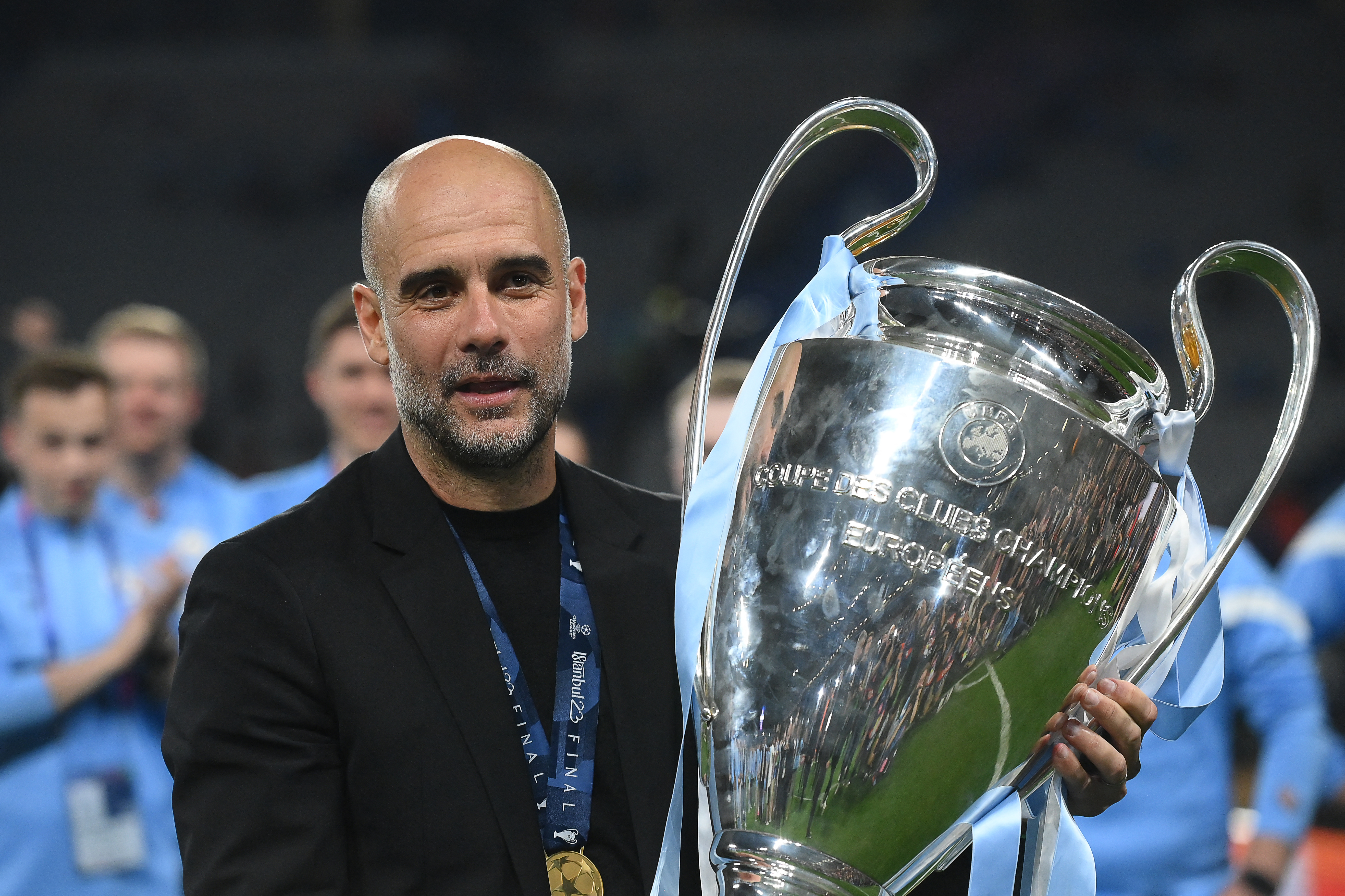 Pep Guardiola poses with the Champions League trophy after Manchester City's win in the final over Inter in June 2023.