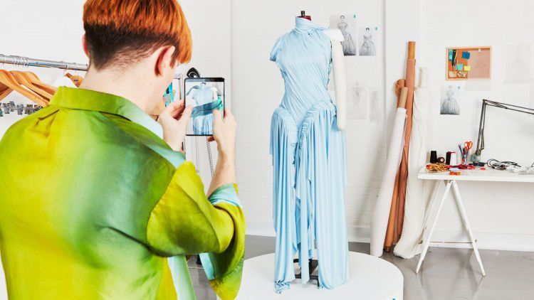 Richard Malone, the designer of the 5G augmented reality dress, interacting with their creation. 