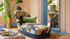 Small living room with colorful lounger and large potted plants. The walls are painted in Benjamin Moore's Desert View