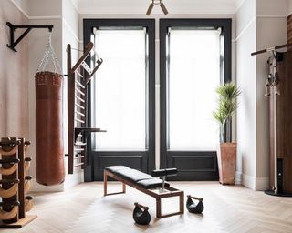 a home gym with punching bag, weights and excercise equipment - NW3 Interiors