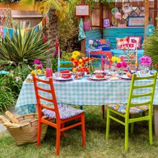 outdoor dining table with colourful table decor and garden bunting