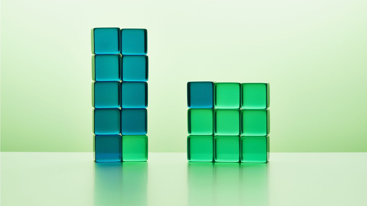 Two uneven stacks of clear green and blue cubes. 