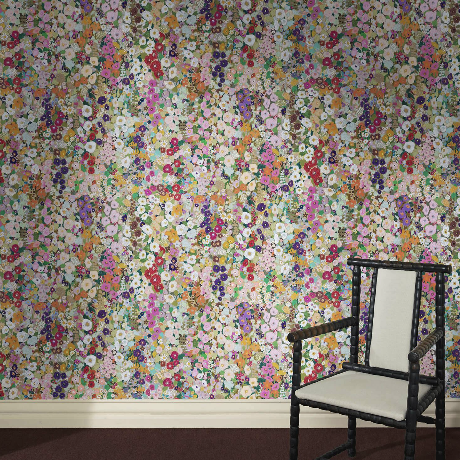 floral wallpaper on a wall with a black chair in front of it