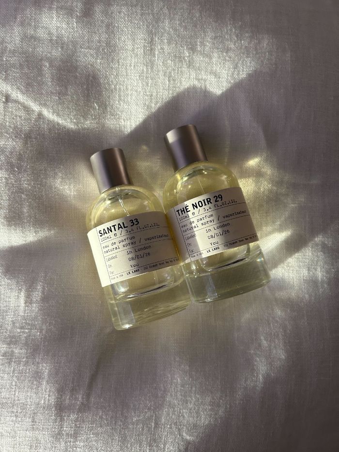 Two Le Labo perfumes on a white linen background