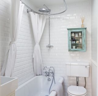 bathroom with white brick tile wall bathtub and commode