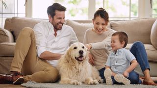 Parents and child sitting with golden retriever