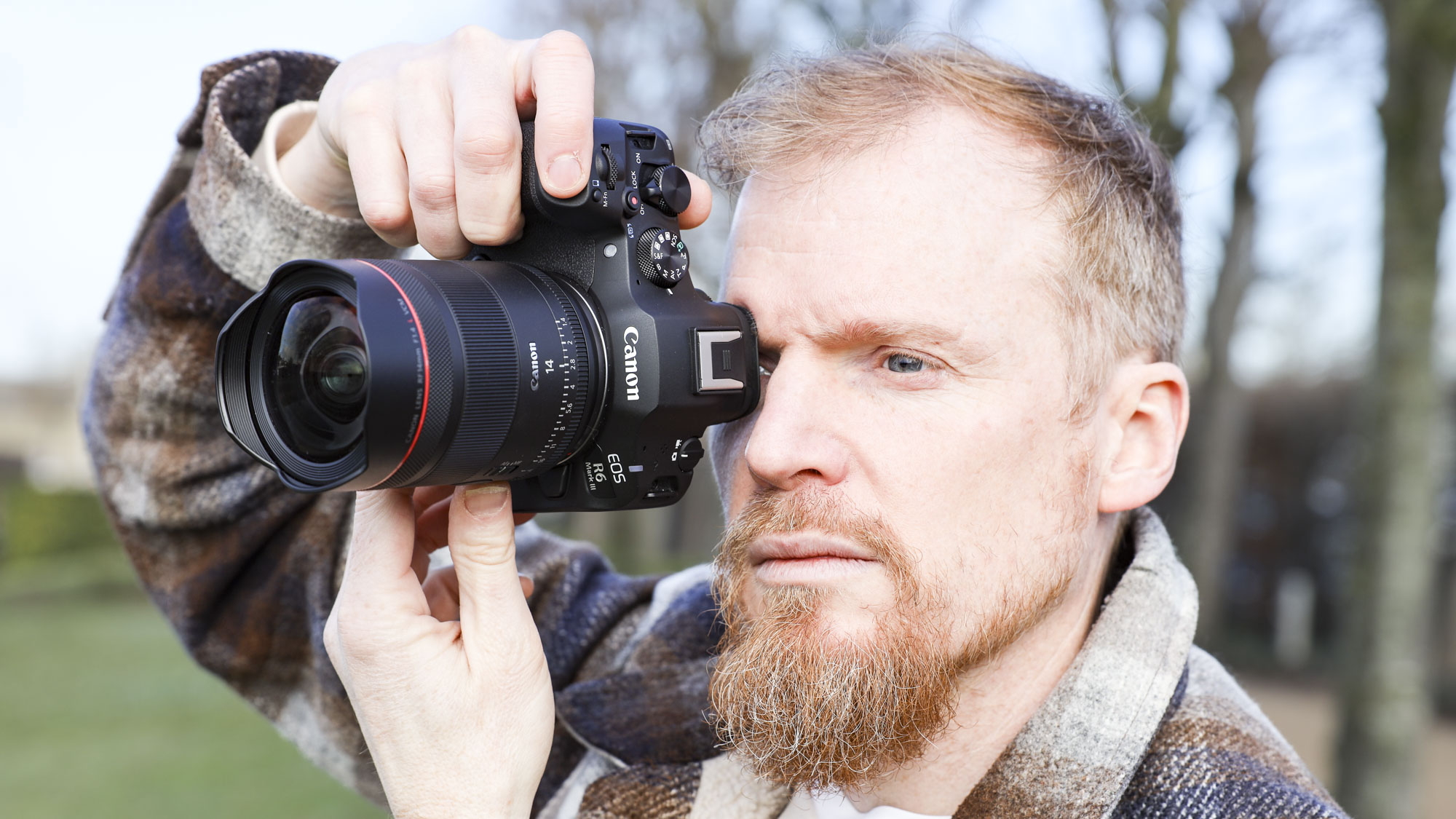 Canon RF 14mm F1.4L VCM lens in photographer Tim Coleman's hands, attached to an EOS R5 mark II