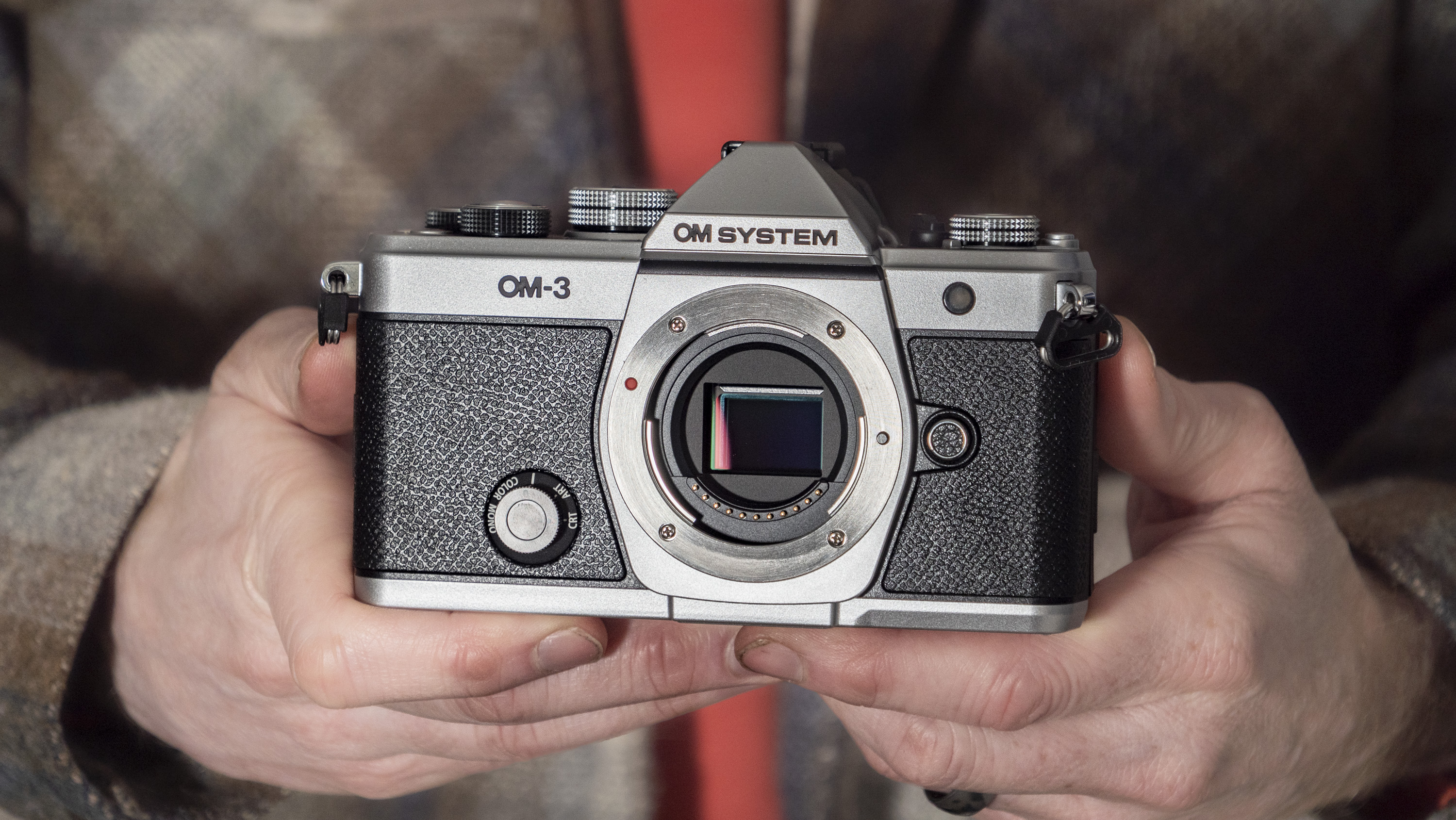 OM System OM-3 mirrorless camera in the hand, no lens attached