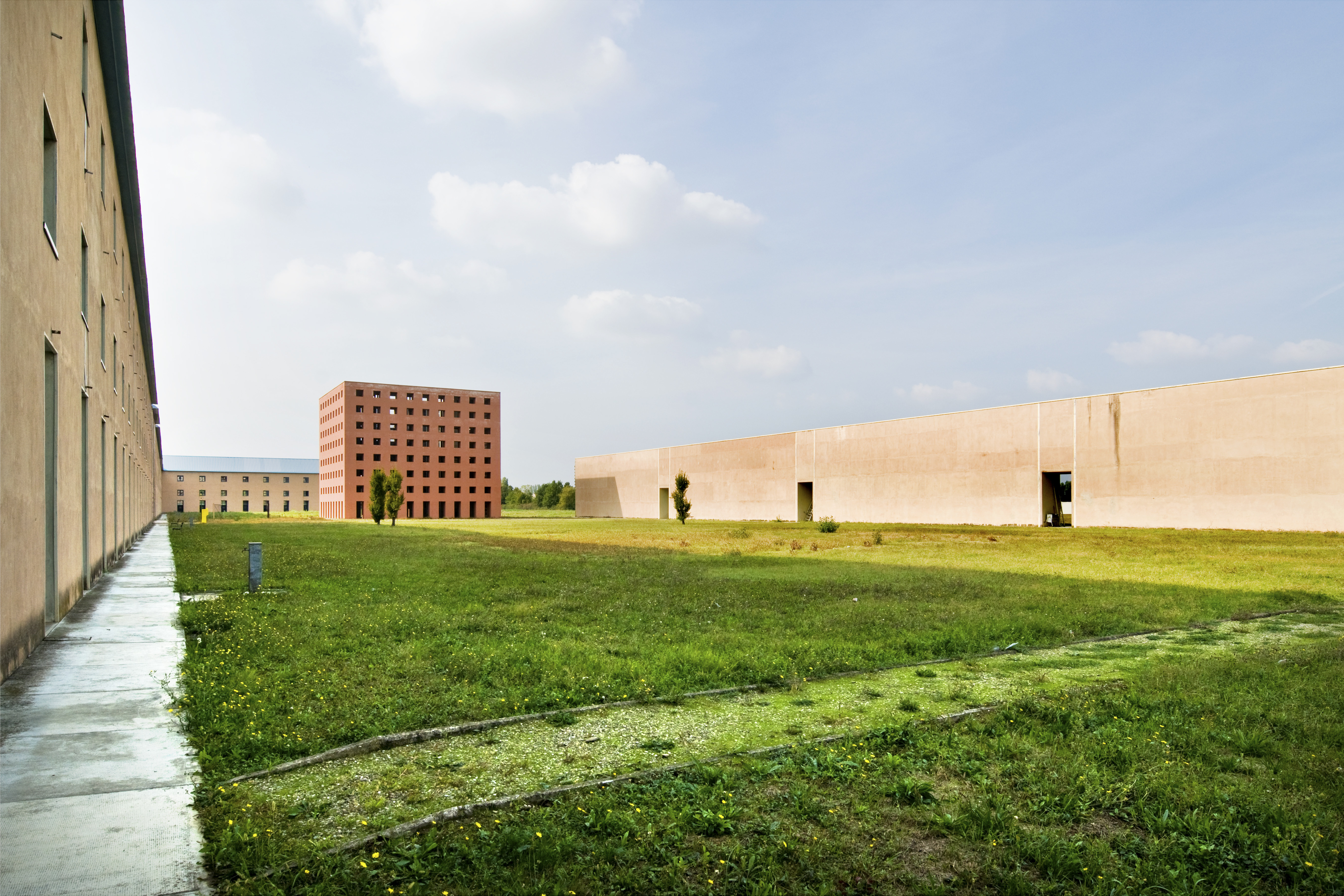 view of the geometric shapes of Aldo Rossi's Cemetery of San Cataldo on a sunny day
