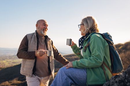Older couple on a mountain having coffee 