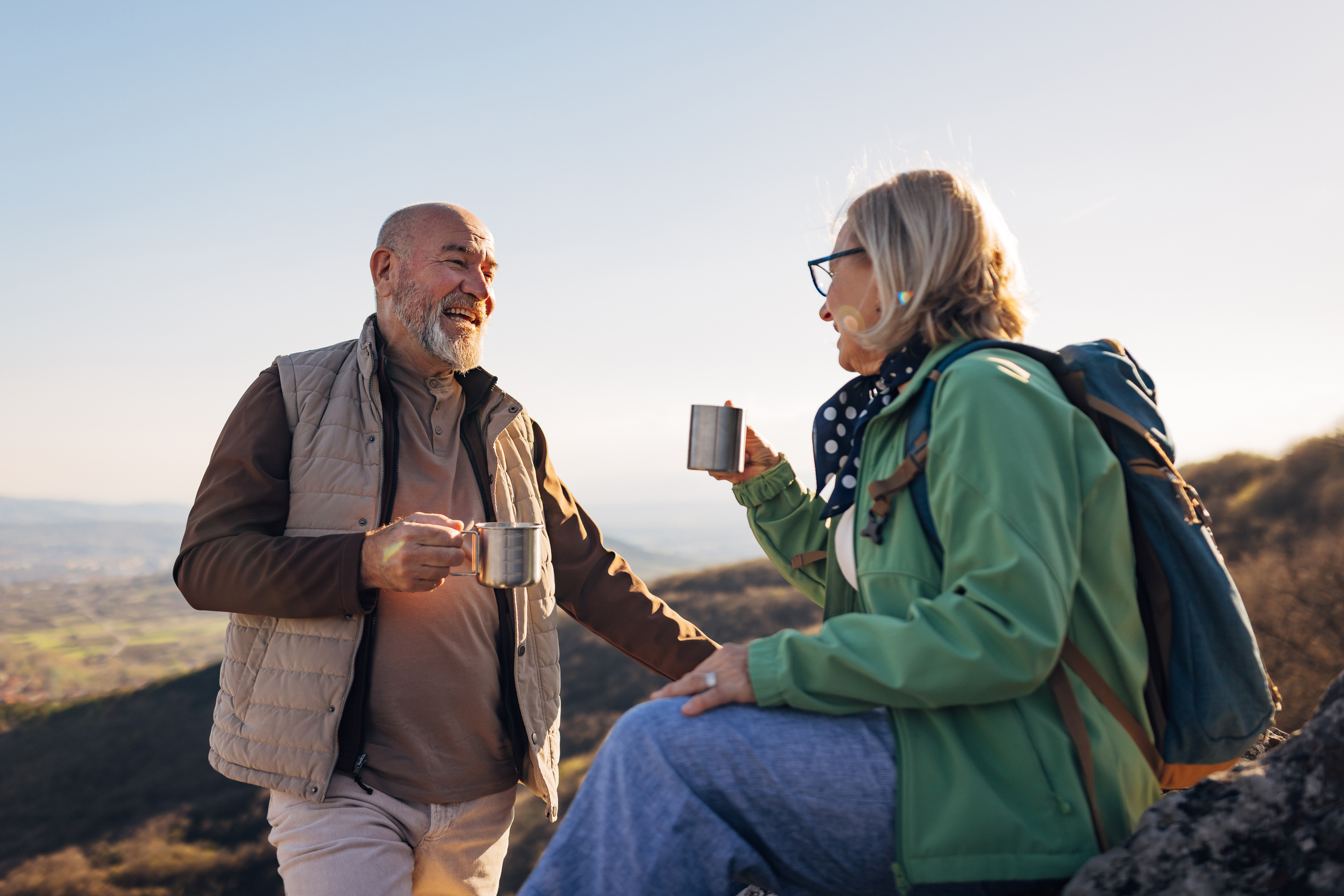 Older couple on a mountain having coffee 