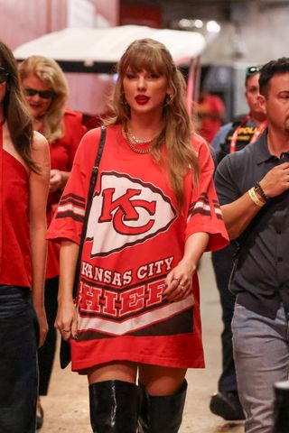 Taylor Swift wearing a chiefs t shirt like a mini dress to a chiefs game