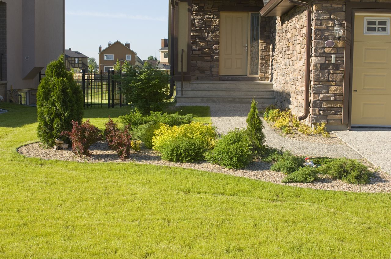 A front yard with a well kept lawn