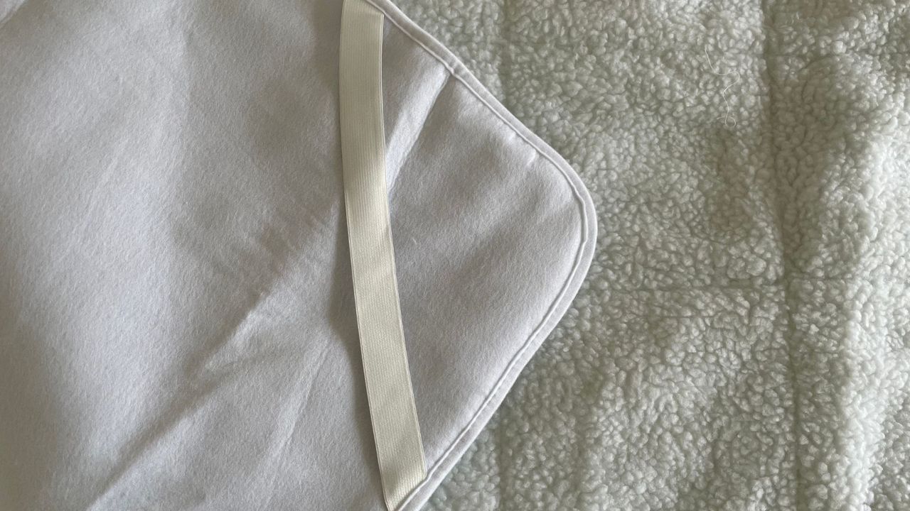 Elastic strap on the Dreamland Hunker Down Skandi Sherpa Blanket