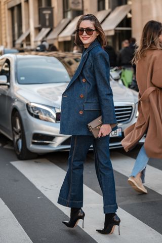 Olivia Palermo wears black top, blue denim blazer with matching flared jeans, taupe Hermes bag, black heels, outside Zimmermann, during the Womenswear Fall/Winter 2024/2025 as part of Paris Fashion Week on March 04, 2024 in Paris, France.