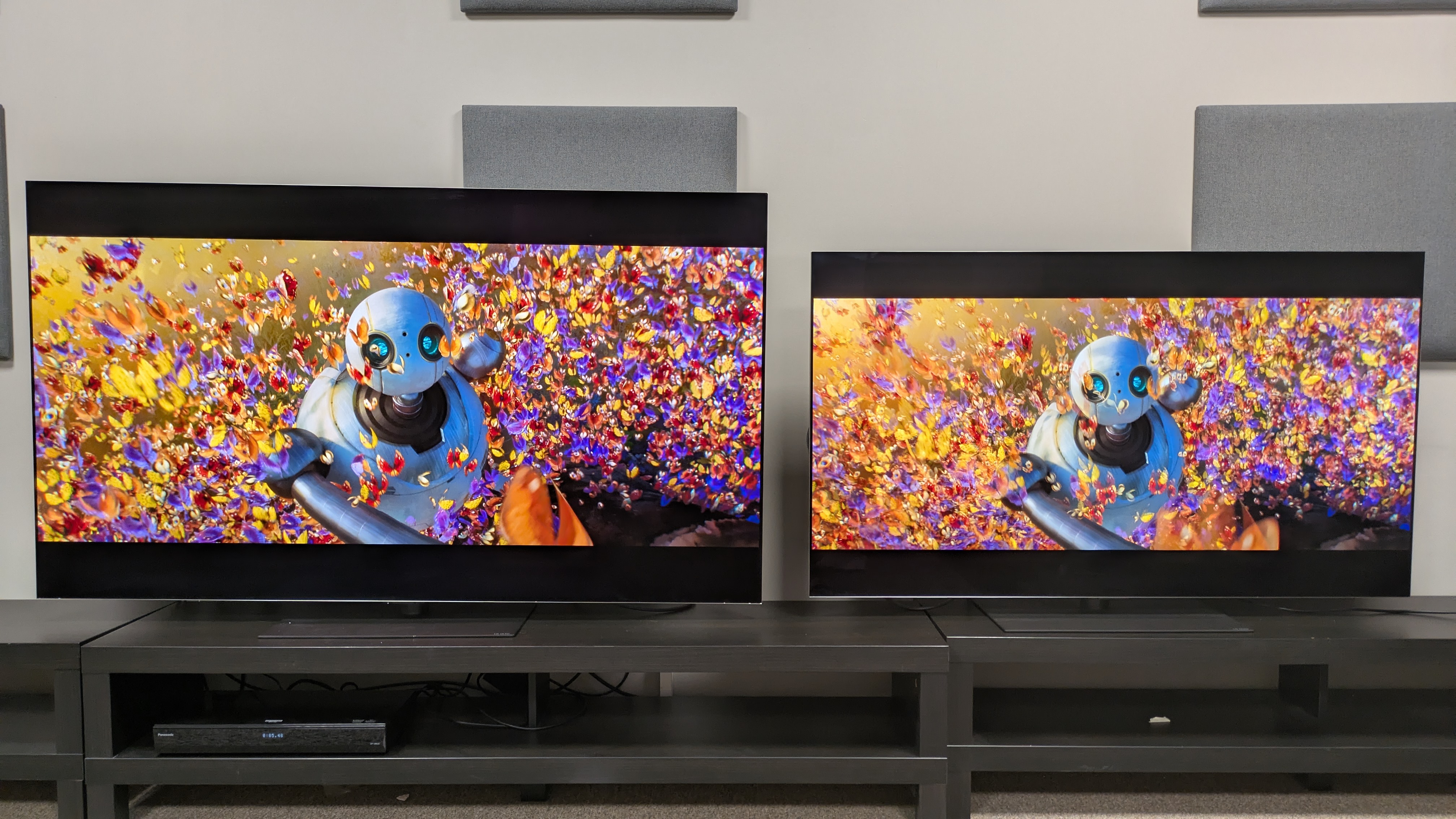 The LG G6 (left) and LG G5 (right) showing scene from The Wild Robot where Roz is surrounded by butterflies, with the G5's colors appearing brighter but the G6's colors appear richer