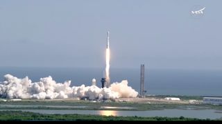 a white rocket launches into a blue sky