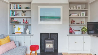 A grey-painted living room with built-in shelves in alcoves