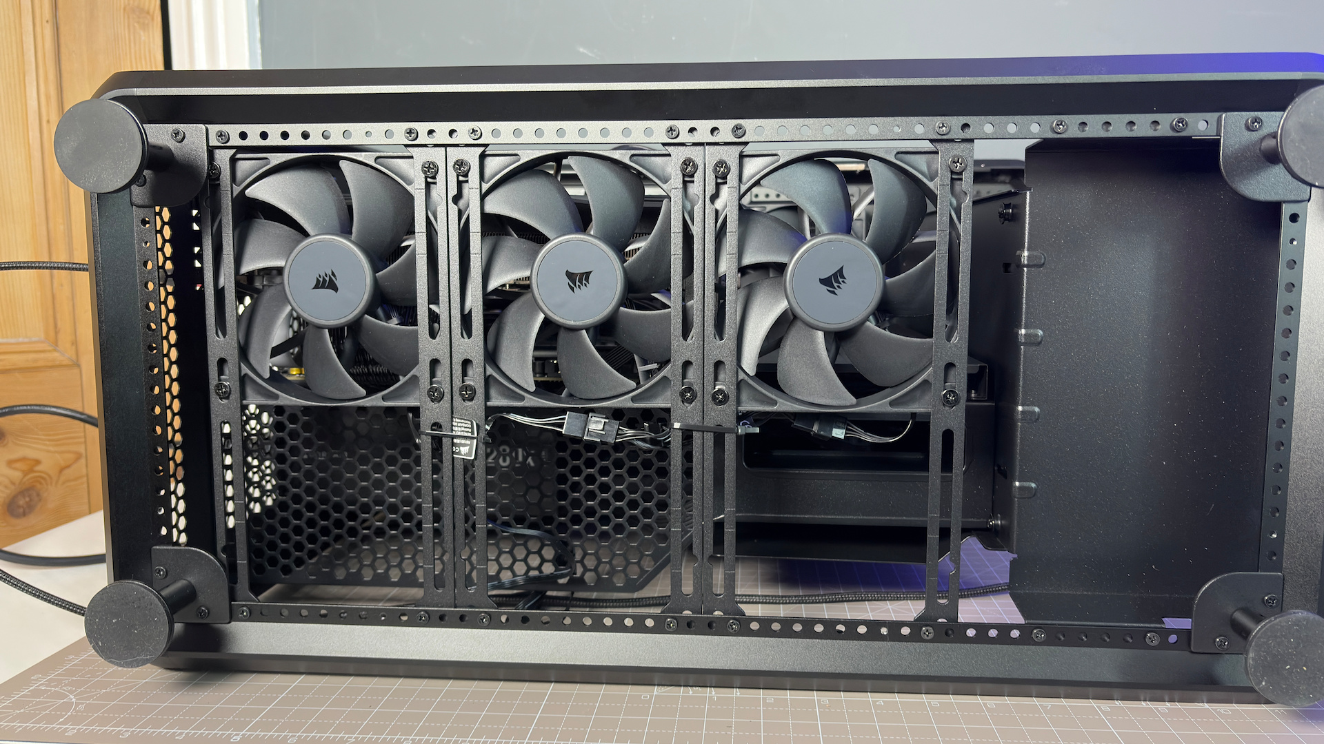 The CoolerMaster MasterFrame 360 Panoramic PC case with various components installed on a desk.