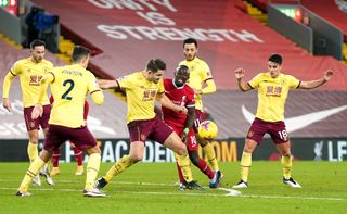 James Tarkowski tackles Liverpool forward Sadio Mane surrounded by other Burnley players