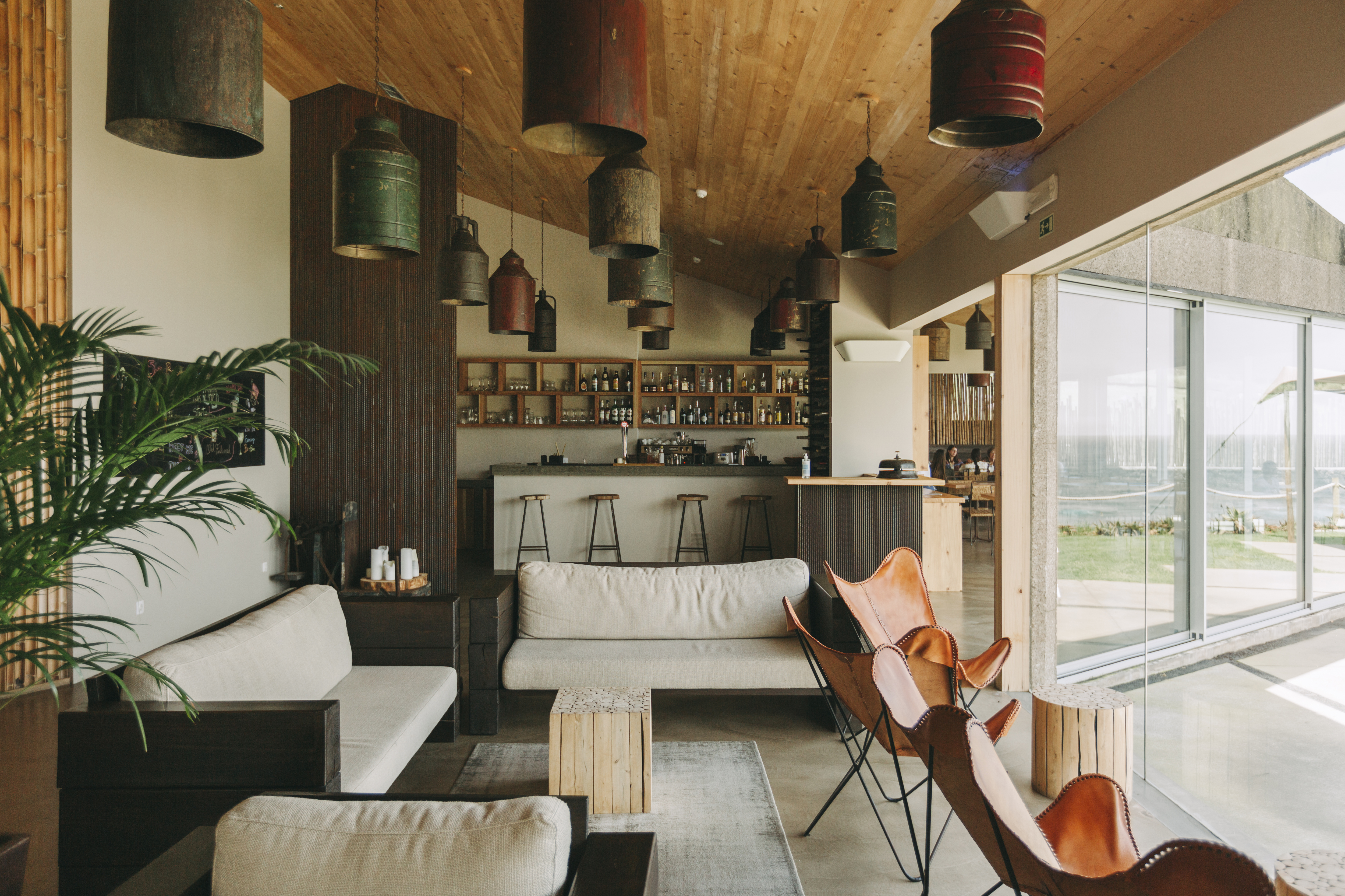 An eco-resort punctuated by wooden finishes, thriving plants, and mid-century modern furniture, as well as breathtaking coastal views.