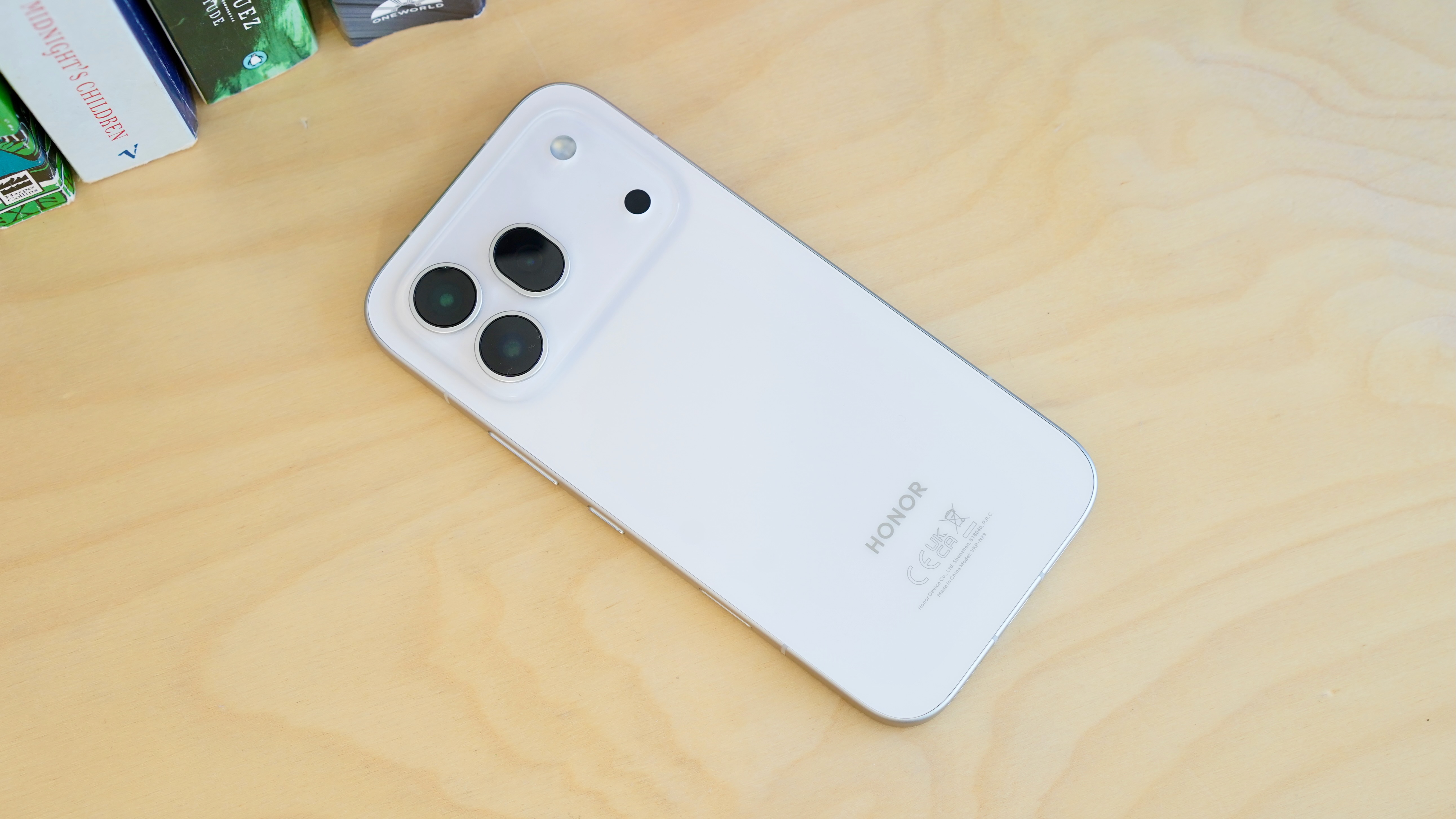 A white Honor 600 Pro resting on a wooden table