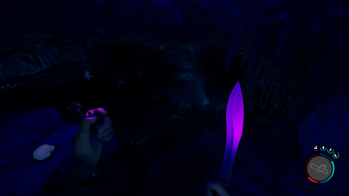 Sons of the Forest - a very dar cave viewed from above of a ledge.