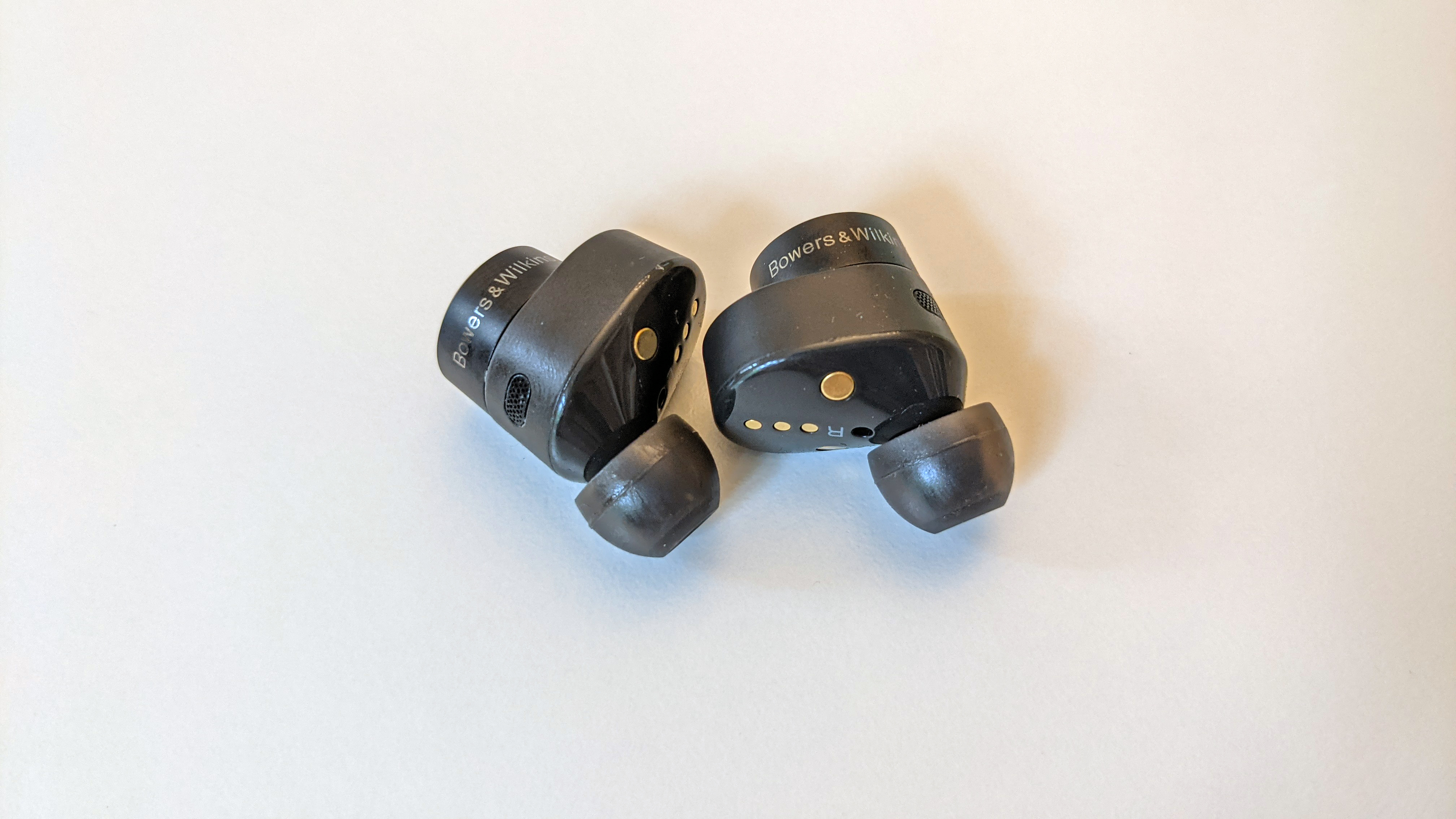 Anthrazitfarbene Bowers & Wilkins PI5 True Wireless liegen auf einem weißen Tisch