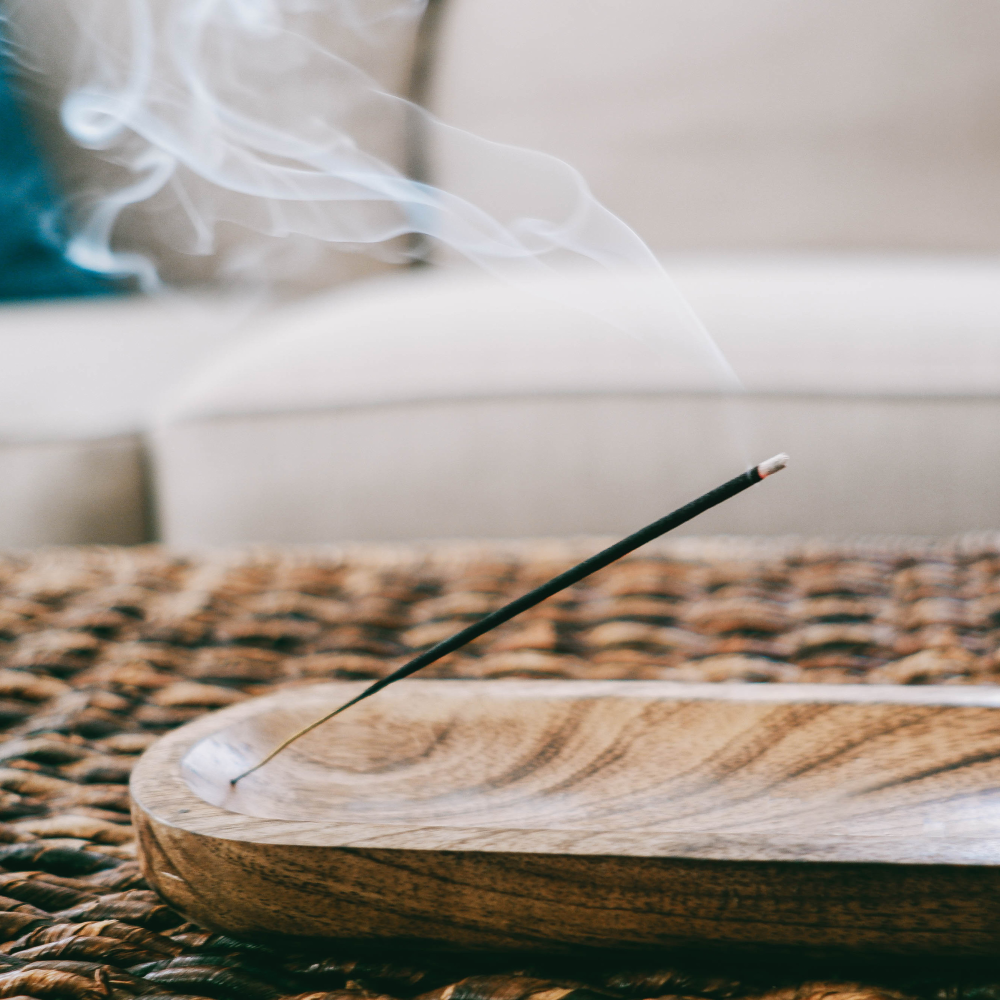 Close up of lit inscense stick on a coffee table.