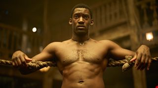 A shirtless Hezekiah Moscow (Malachi Kirby) rests against the ropes of a boxing ring in a scene from "A Thousand Blows" season 1